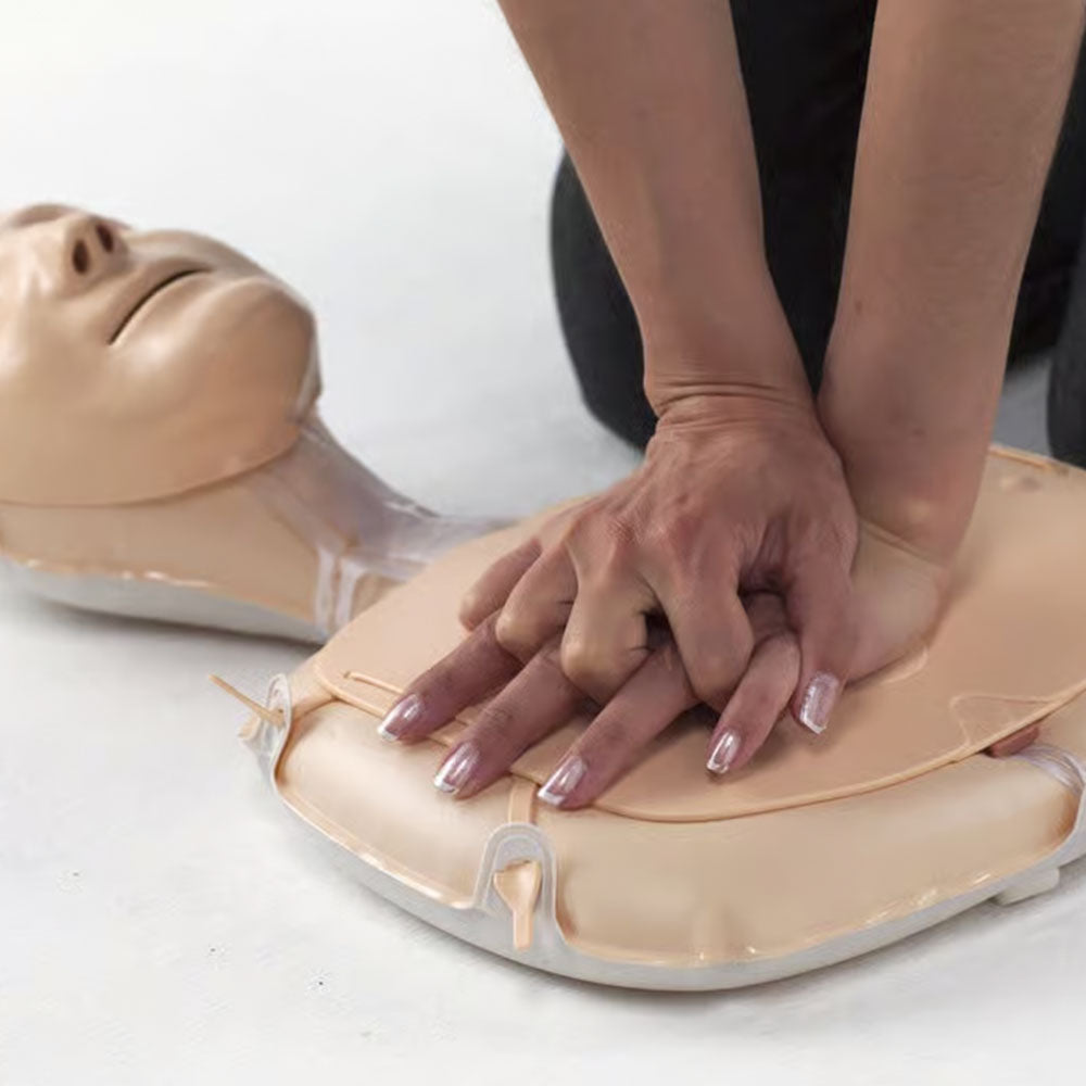 A person practicing CPR on the Laerdal Mini Anne.