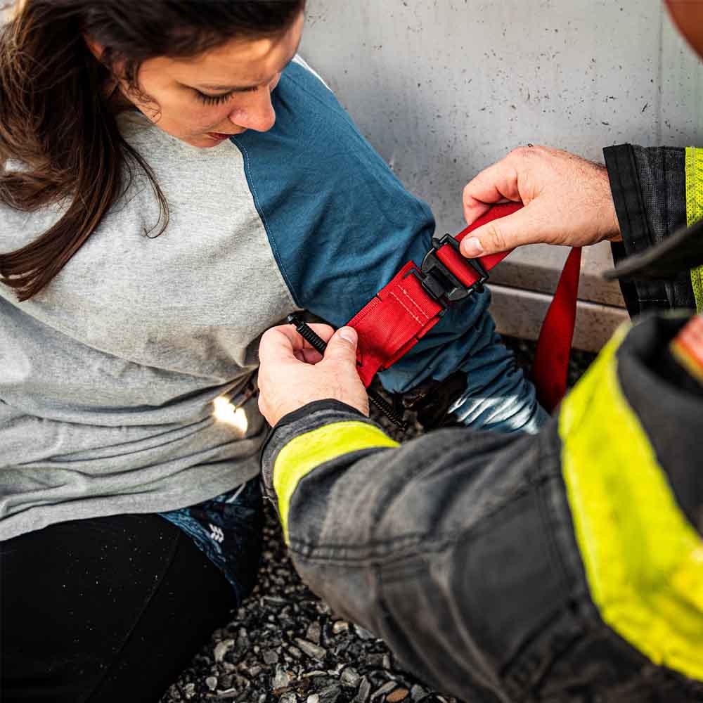 A first responder using the TacMed SOF Tourniquet on a woman.