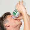 A man using a bottle of Cederroth Eye Wash.