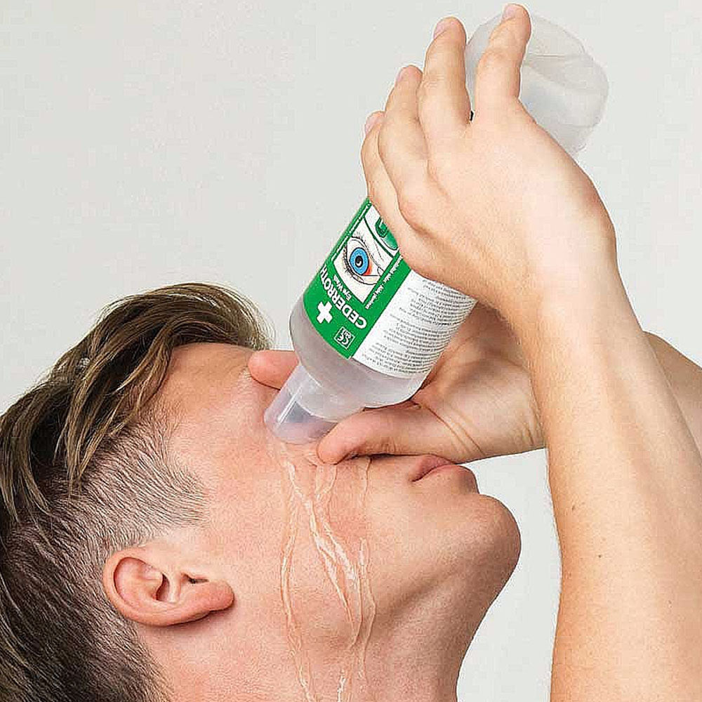 A man using a bottle of Cederroth Eye Wash.