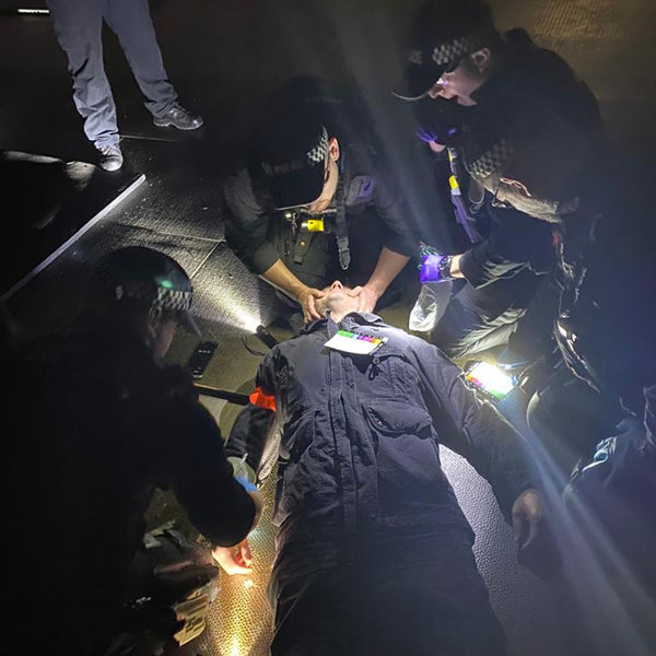 A first aid and specialist trauma course, with emergency responders helping an unconscious person.