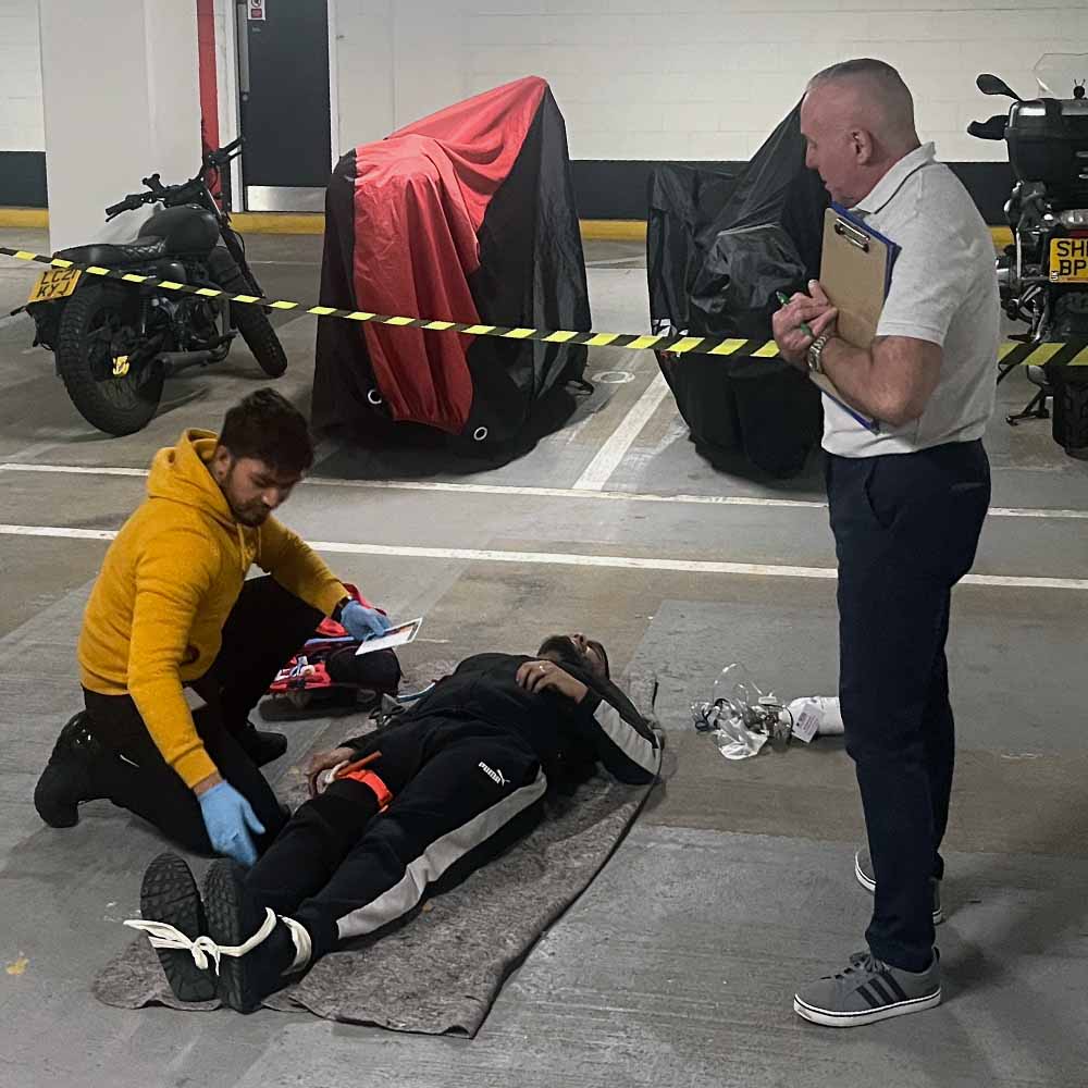 A learner and instructor on a First Aid and Specialist Trauma (FAST) course, at a parking garage.