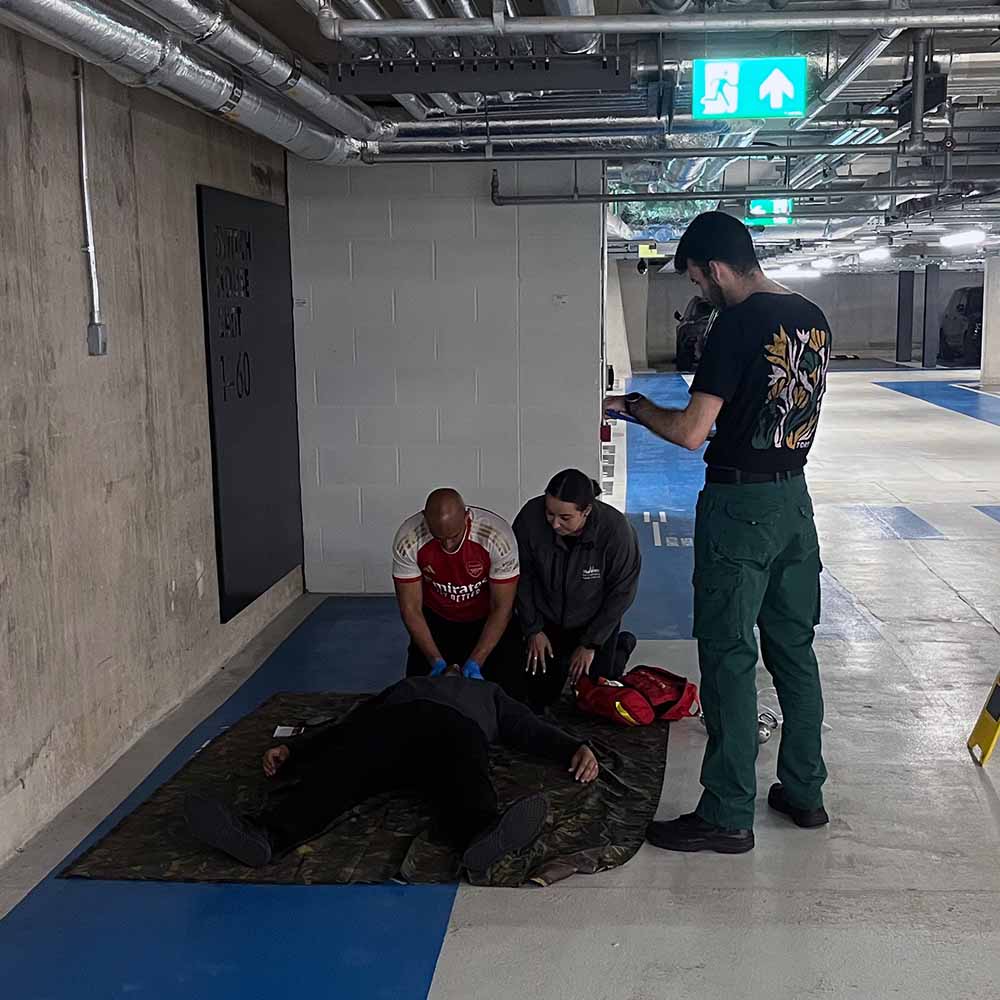 A first aid and specialist trauma course, with learners practising skills in a parking garage.