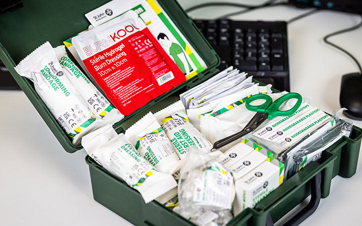 First aid kit with various supplies on a desk