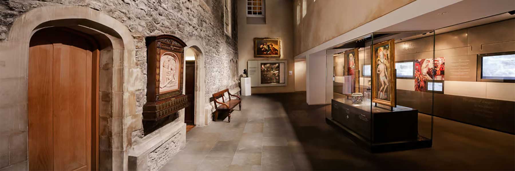 Museum interior with stone walls, wooden doors, and exhibits.